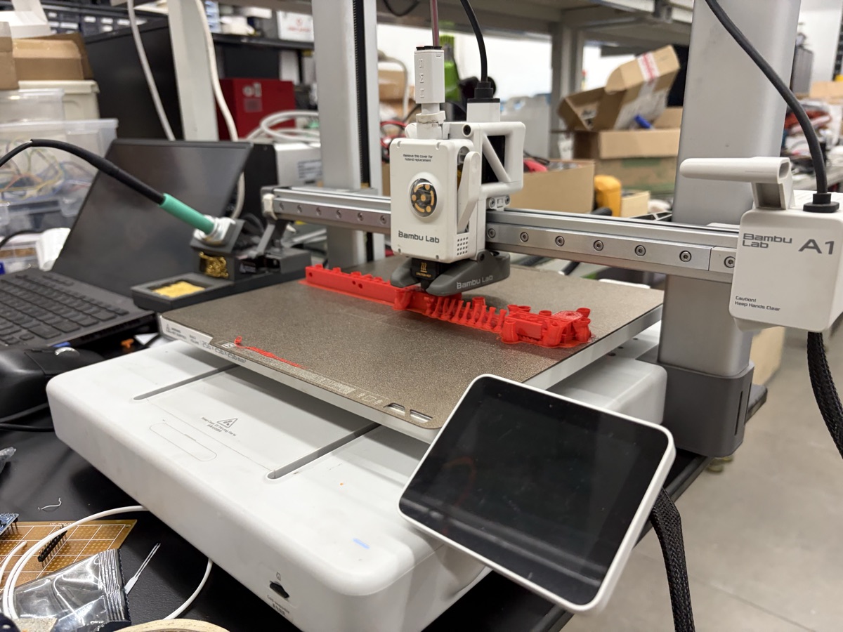 Bambu Lab A1 3D printer printing red prototype parts at Troublemaker, Shenzhen