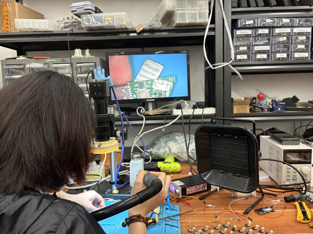 Engineer soldering under digital microscope at Troublemaker workspace, Shenzhen